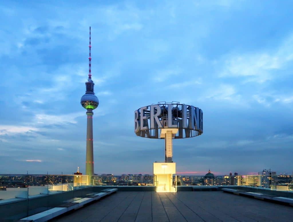 Blauer Himmel und im Hintergrund der beleuchtete Berliner Fernsehturm; Im Vordergrund der Schriftzug "Berliner" auf der Dachterrasse des Berliner Pressehauses